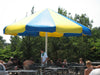 Large blue and yellow USA Shade Coolbrella over a poolside area with people around