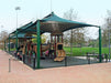 Children's playground with green USA Shade Mariner Pyramid Shade and play structures in a park setting.