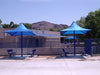 Blue USA Shade Lifeguard Umbrellas and chairs on a concrete surface with mountains in the background