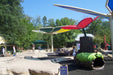 Children's playground with colorful USA Shade Butterfly Wings Shade and people around