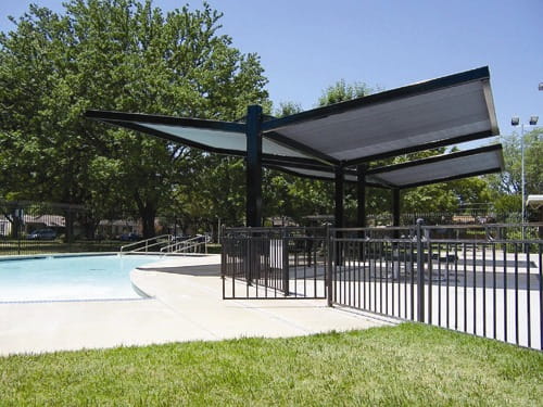 USA Shade Slanted Cantilever Framed Double Unit by a pool with trees in the background