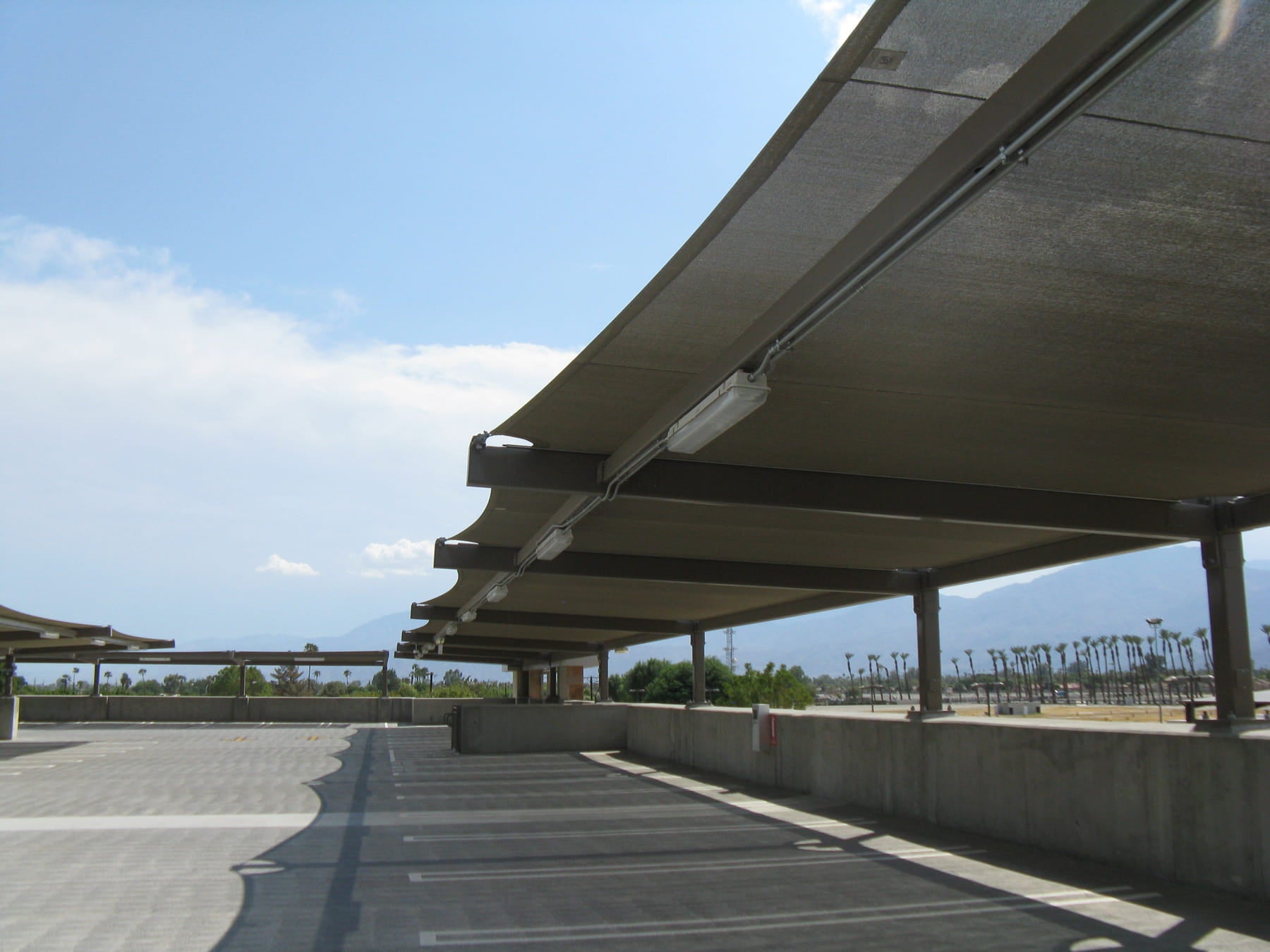 Long USA Shade Slanted Cantilever Cabled in parking lot with a clear blue sky