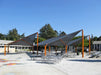 Outdoor seating area with USA Shade Wave Shade and picnic tables in a school setting