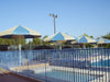 USA Shade Coolbrellas and a pool area with a blue fence under a clear sky.