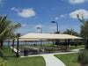 Outdoor dining area with a USA Shade Hip under a clear blue sky