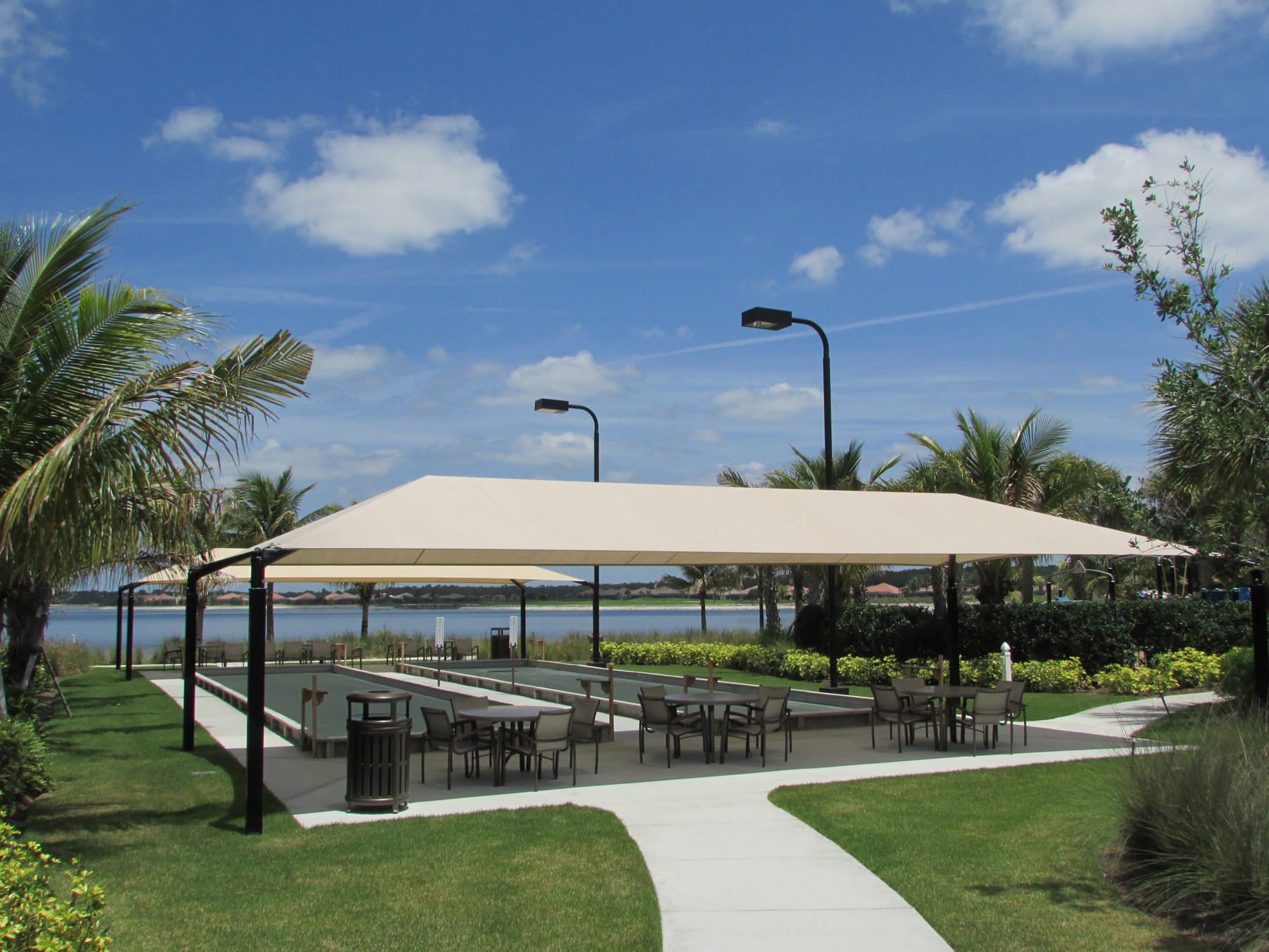 Outdoor dining area with a USA Shade Hip under a clear blue sky