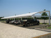 USA Shade Full Arch Cantilever with multiple vehicles parked underneath on a clear day