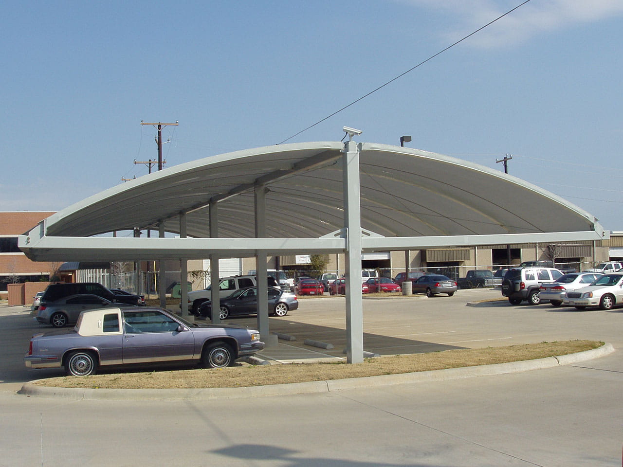 USA Shade Full Arch Cantilever with multiple cars parked underneath on a clear day