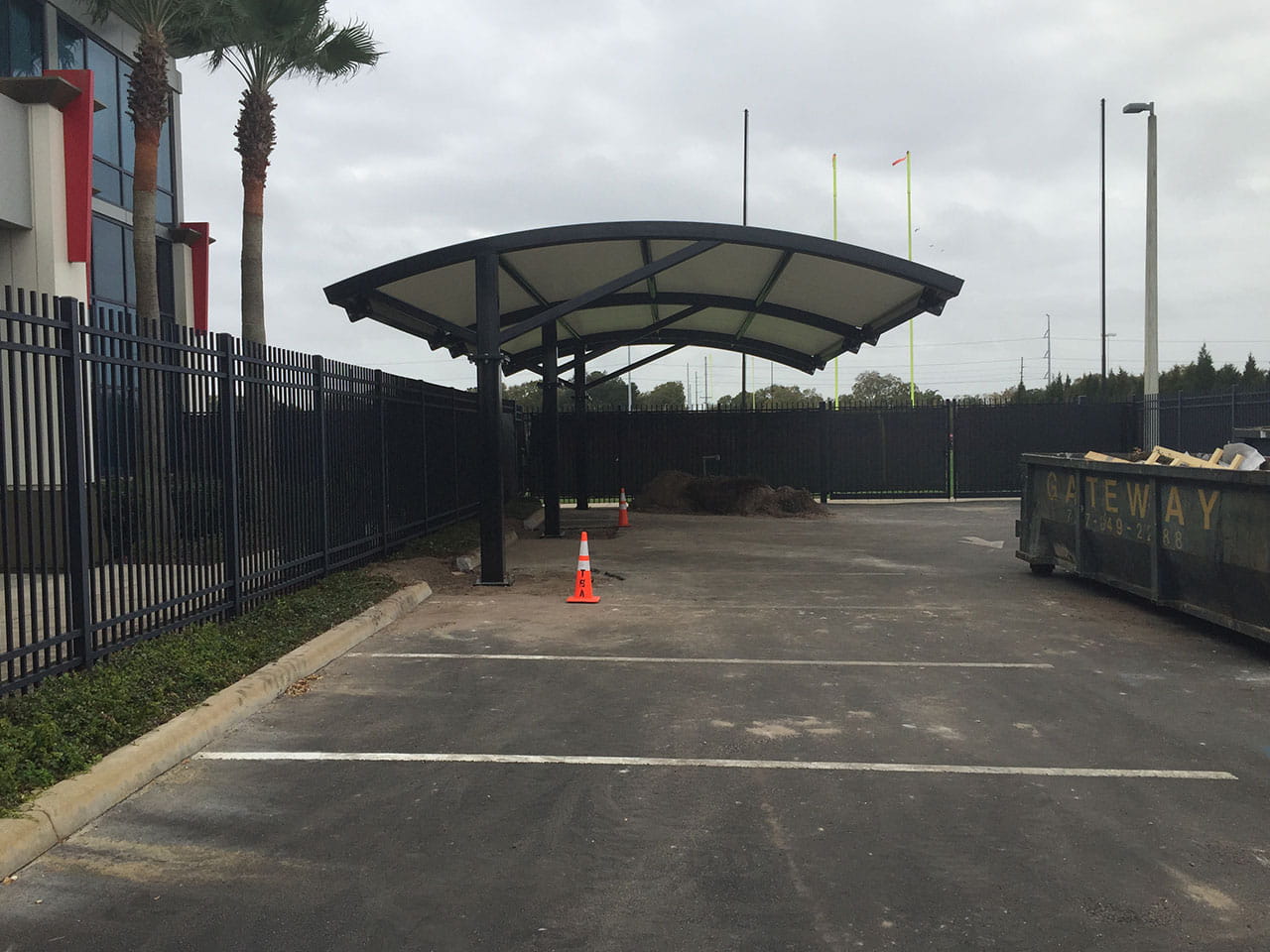 Covered parking area with a USA Shade Panorama Cantilever in an outdoor setting