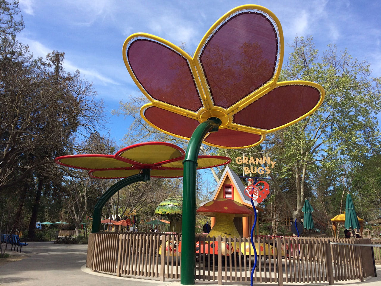 Colorful USA Shade Flower Shade Structure with 'Granny Bugs' sign in a park setting