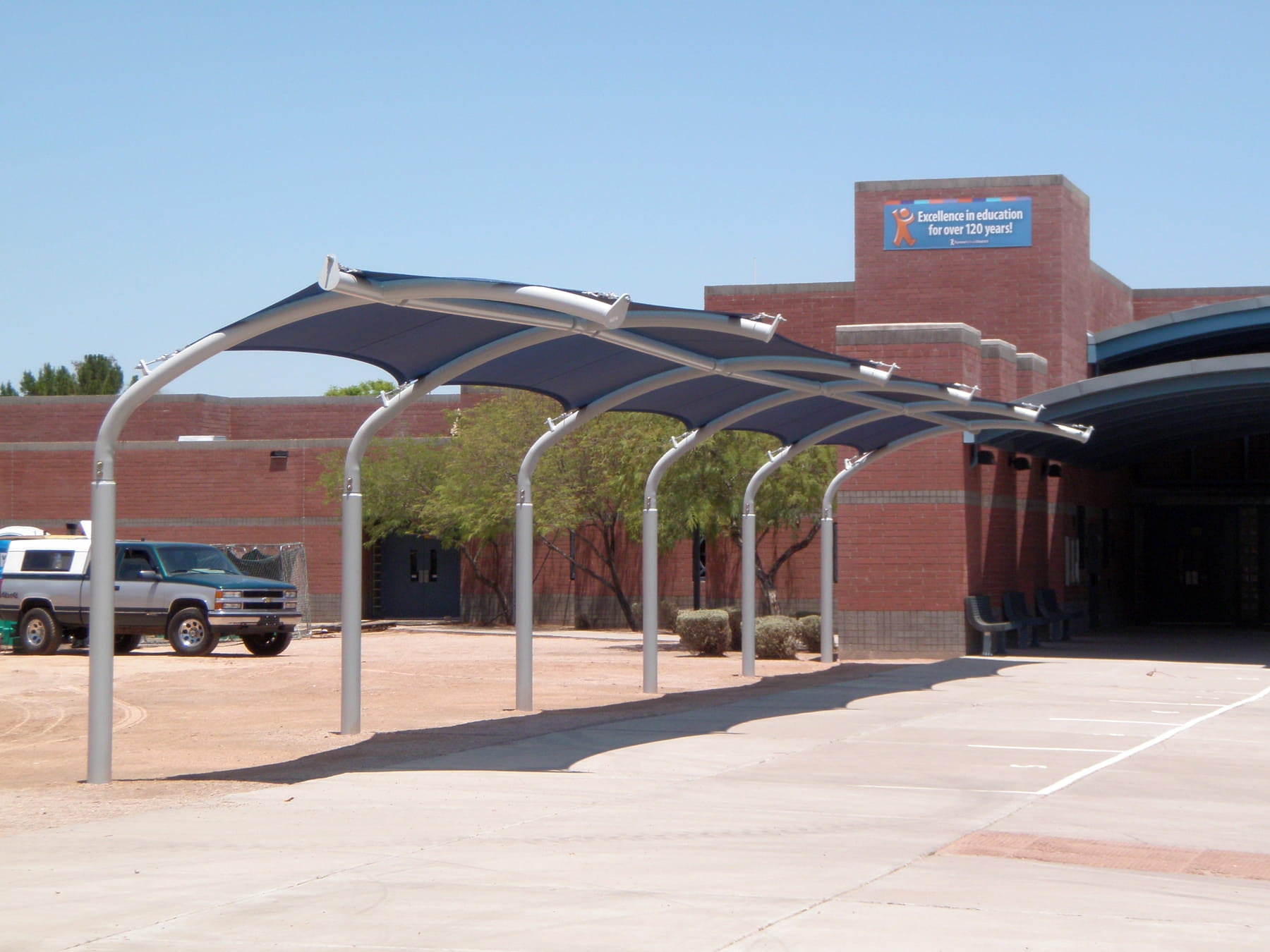 USA Shade Cantilever Arch Walkway with a building in the background on a clear day