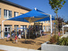 Children playing on a playground with blue USA Shade Mariner Pyramid Shade under a clear blue sky.