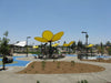 Children's playground with a large yellow USA Shade Flower Shade Structure on a clear day.