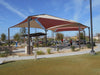 Pavilion with red and beige USA Shade Multi-Panel Hip in a park setting