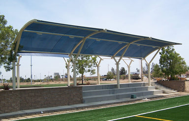 Covered seating area with blue USA Shade Eclipse Cantilever and concrete steps leading up to it, set against a clear sky.