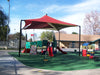Children's playground with a USA Shade Mariner Pyramid Shade canopy, slides, and play equipment on a sunny day.