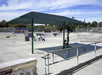Skate park with a green USA Shade Two Post Hip Shade Structure providing shade