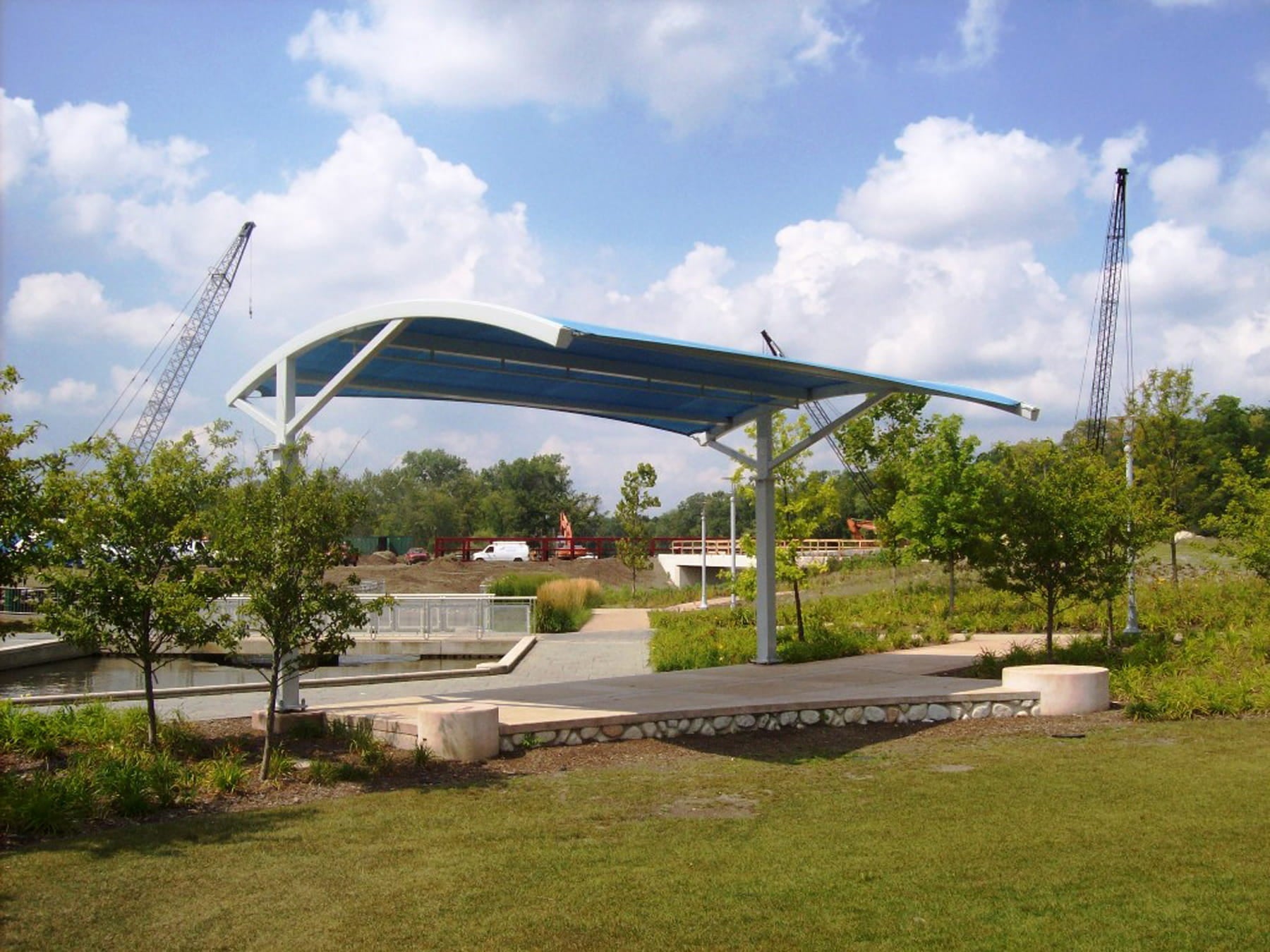USA Shade Panorama Cantilever with a blue roof in a park setting under a cloudy sky