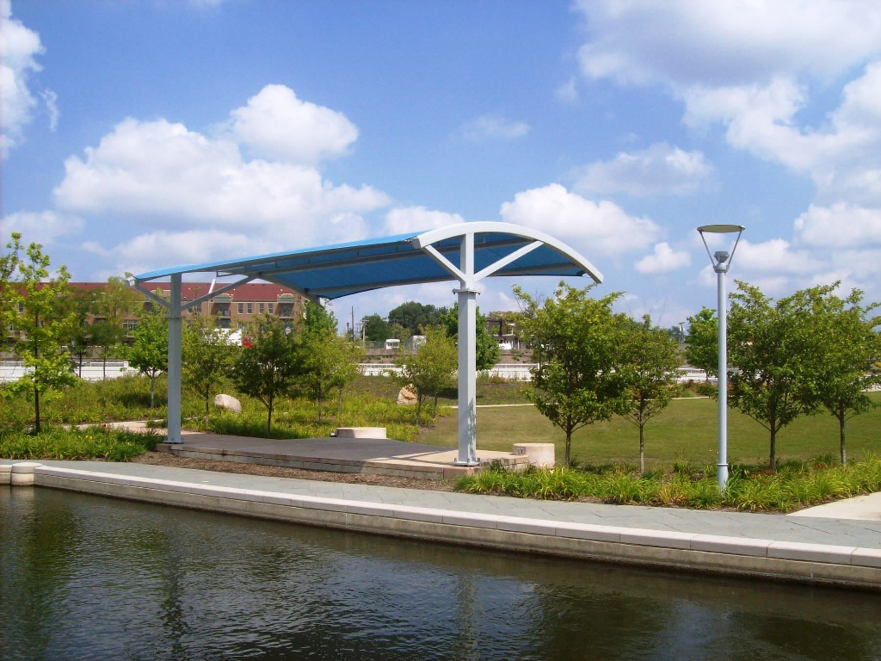 USA Shade Panorama Cantilever by a water body with trees and buildings in the background