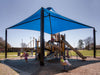 Children playing on a playground with a blue USA Shade Sahara Shade on a sunny day.