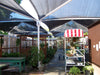 Outdoor area with USA Shade Hips giving shade to plants, and a small table.