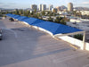 Blue USA Shade Full Hip Cantilever Shades over a parking lot with cityscape in the background