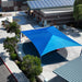 Blue USA Shade Super Span Hip  over a parking area with surrounding buildings and trees.