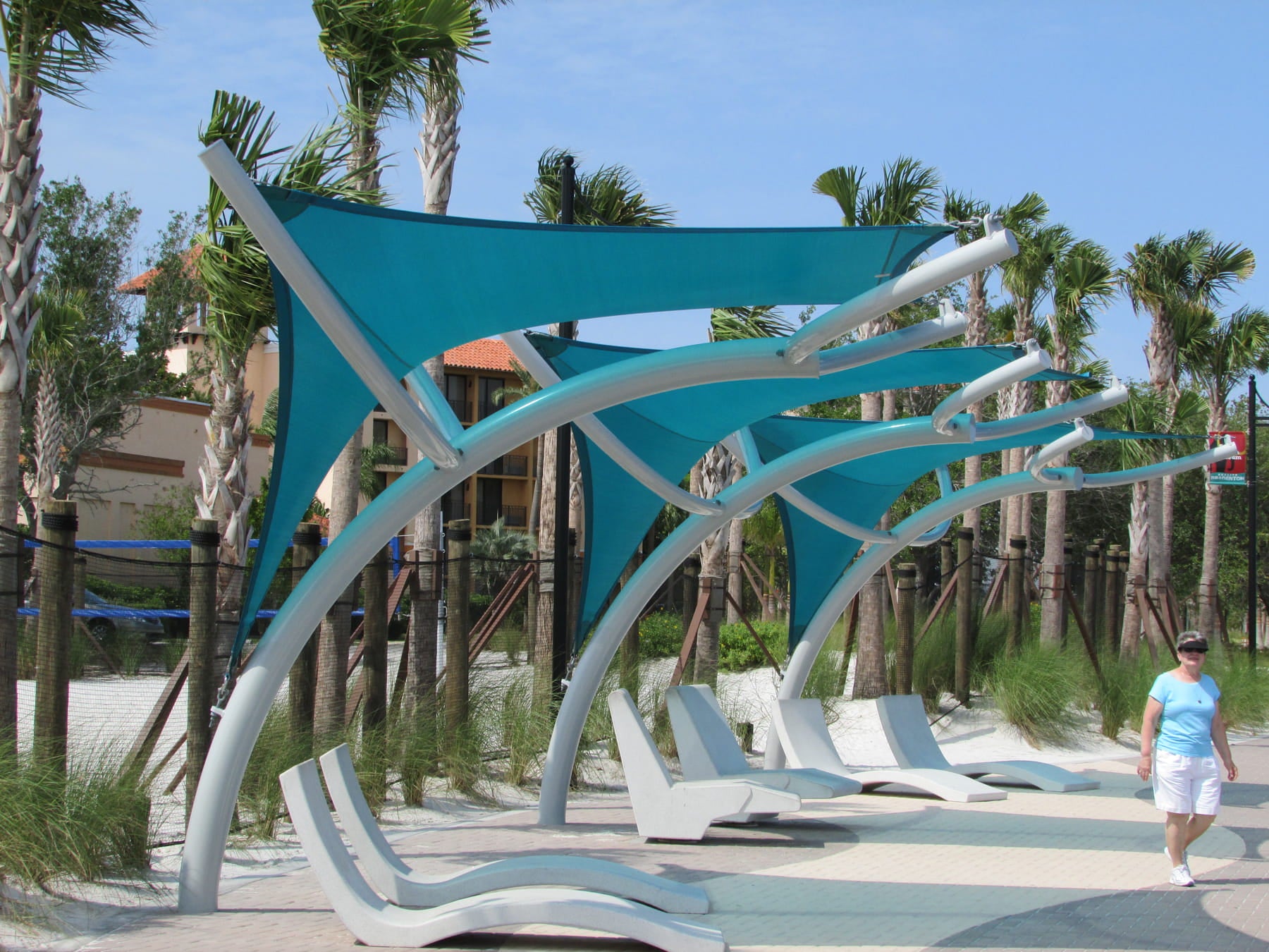 Modern beach chairs with a blue USA Shade Pegasus Shade in a tropical setting