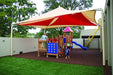 Children playing under a large red and beige USA Shade Mariner Pyramid Shade structure in an outdoor playground.