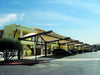 Commercial building with outdoor USA Shade Cypress Cantilevers and parked cars on a clear day