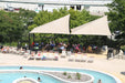 People gathered around a pool under USA Shade Wave Shades and siiting on chairs